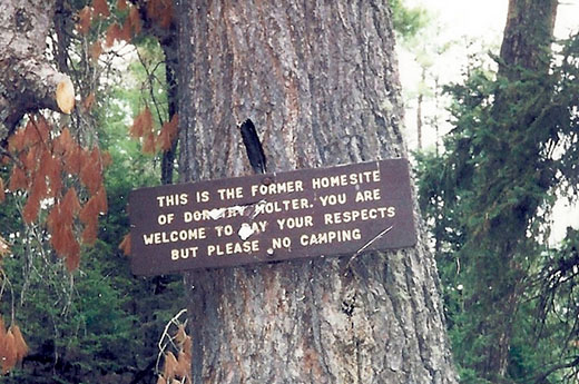 Sign pinned to a tree on the Isle of Pines that states, "This is the former homesite of Dorothy Molter. You are welcome to pay your respects but please no camping."