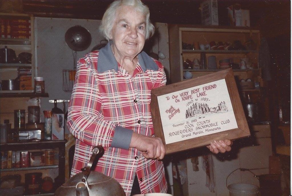 Dorothy Molter holding an honorary plaque awarded to her.