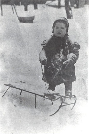 Dorothy as a toddler sledding in the snow.
