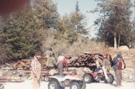  A group of "Dorothy's Angels" standing and on four-wheelers in front of a dismantled building off of Knife Lake.