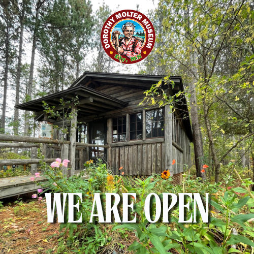 Image of the Winter Cabin with the museum logo and the words we are open